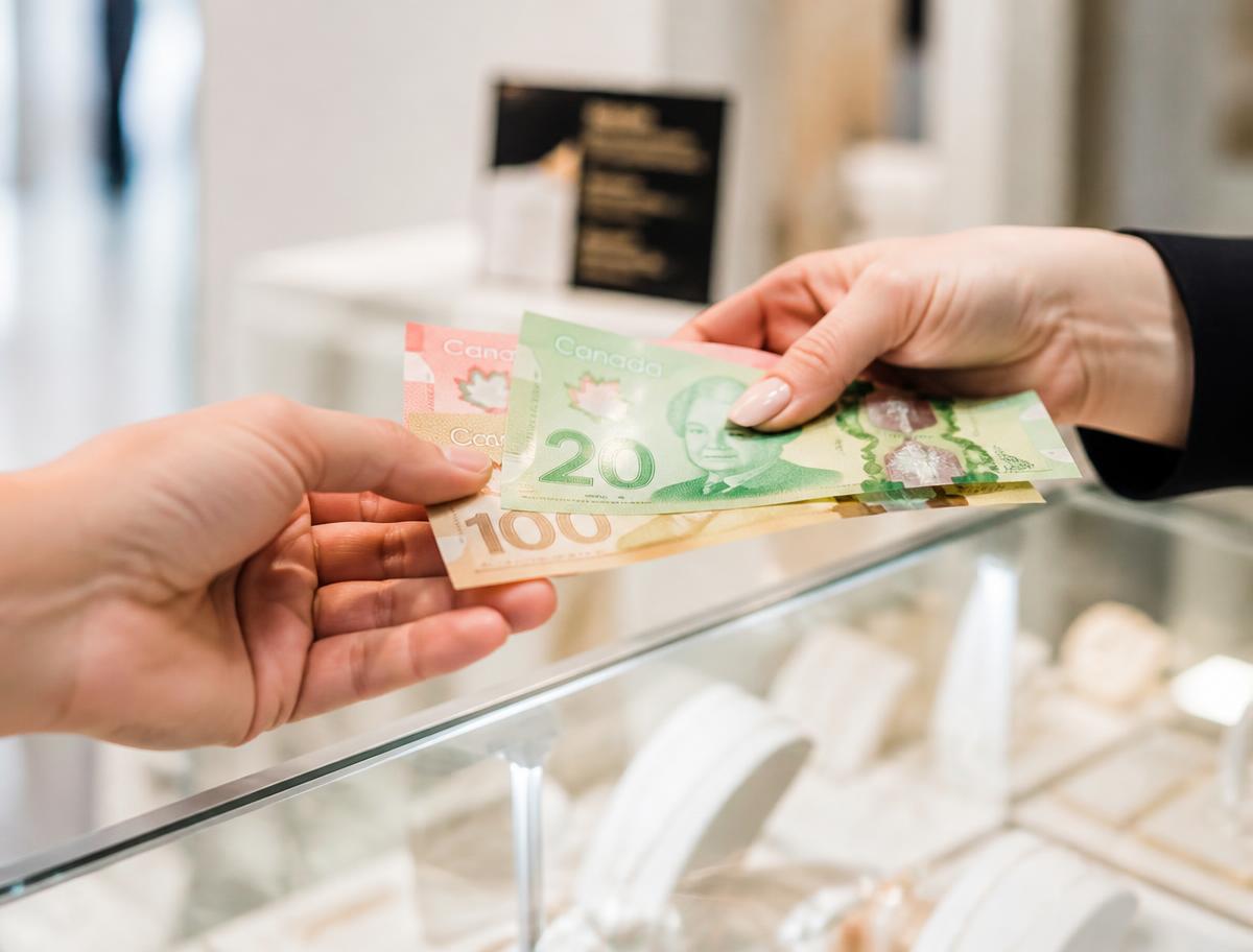 Canadian dollar bills being handed across the shop desk